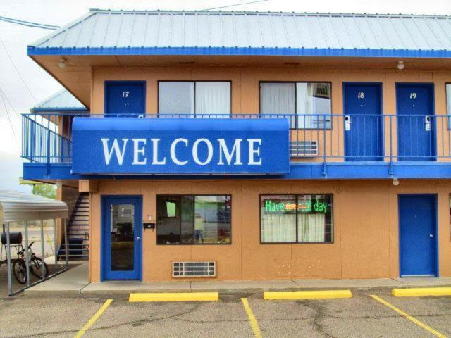 a building with a blue welcome sign on it at Motel 10 in Lordsburg