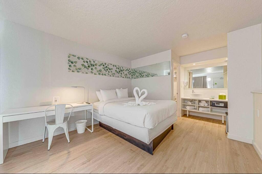 1 dormitorio con 1 cama y escritorio con escritorio en Travel Lodge by Wyndham 10 min from Disney, en Kissimmee