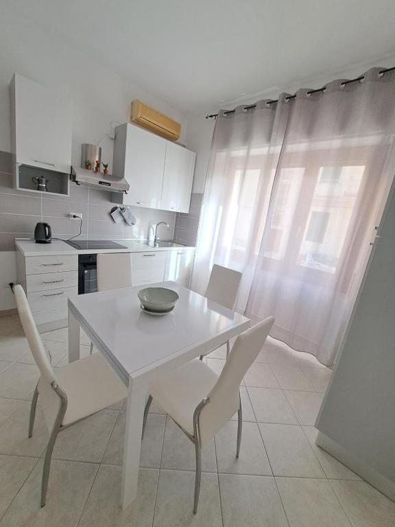 una cucina bianca con tavolo e sedie bianchi di Logudoro Home ad Alghero