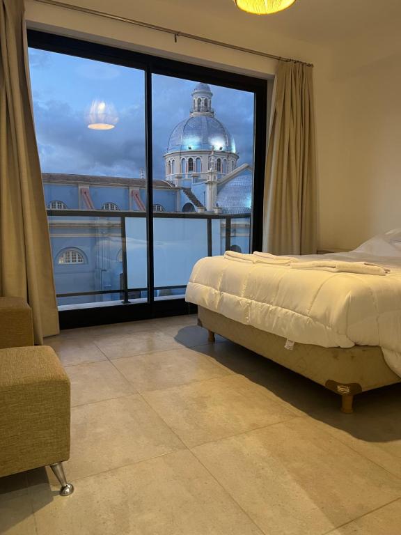 - une chambre avec un lit et une grande fenêtre dans l'établissement Apartamento Mirador de la Viña., à Salta