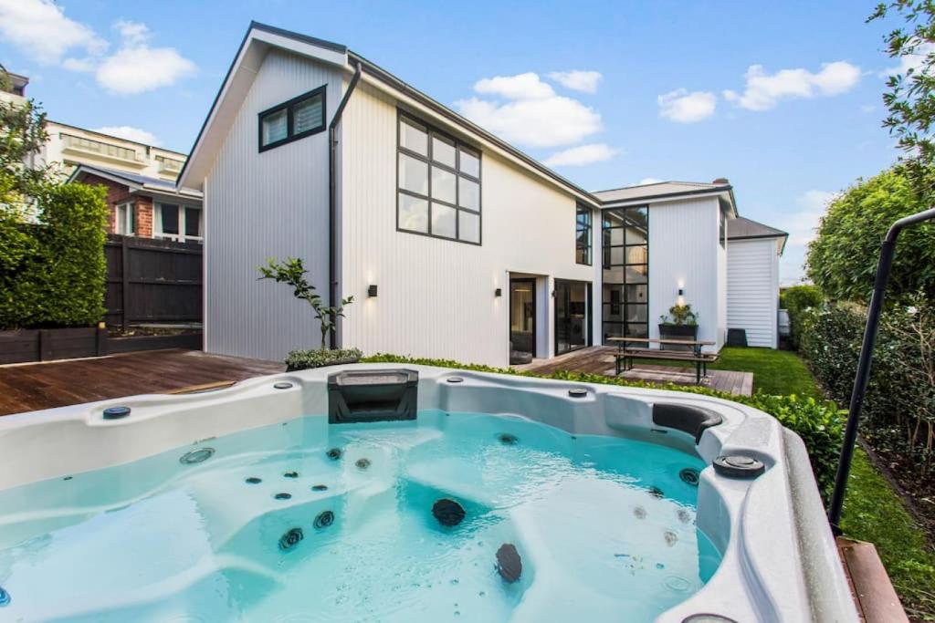 a house with a large hot tub in the yard at Luxury Executive Family Home with Parking & Spa in Auckland
