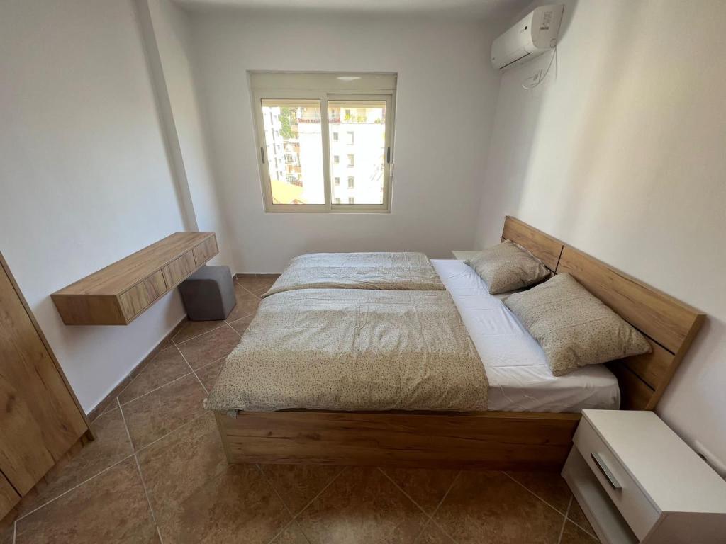 Schlafzimmer mit einem Bett und einem Fenster in der Unterkunft Breeze Seaview Apartment in Durrës