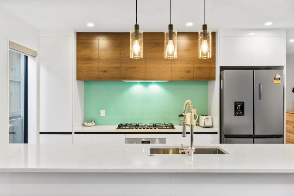 a kitchen with a white counter top and a refrigerator at Modern Family Townhouse in Mt Roskill, Auckland in Auckland