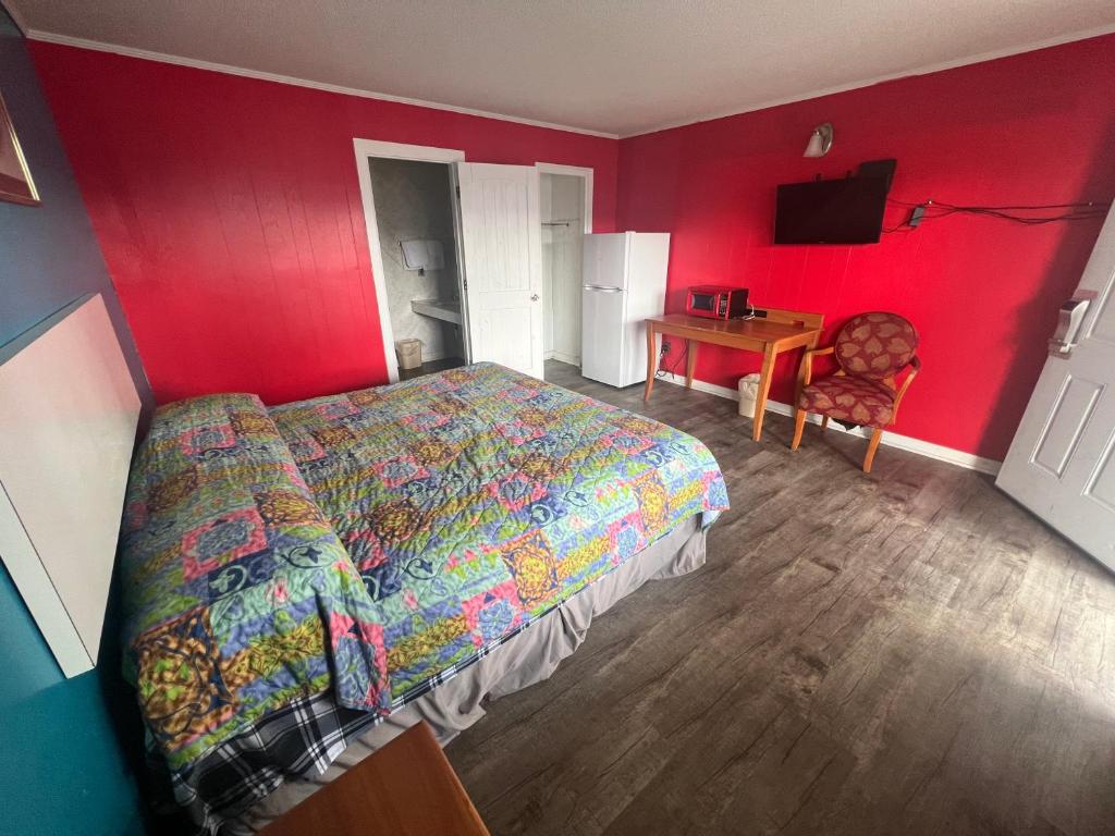a bedroom with a bed and a table and a chair at Pinelodge Motel in Baxley