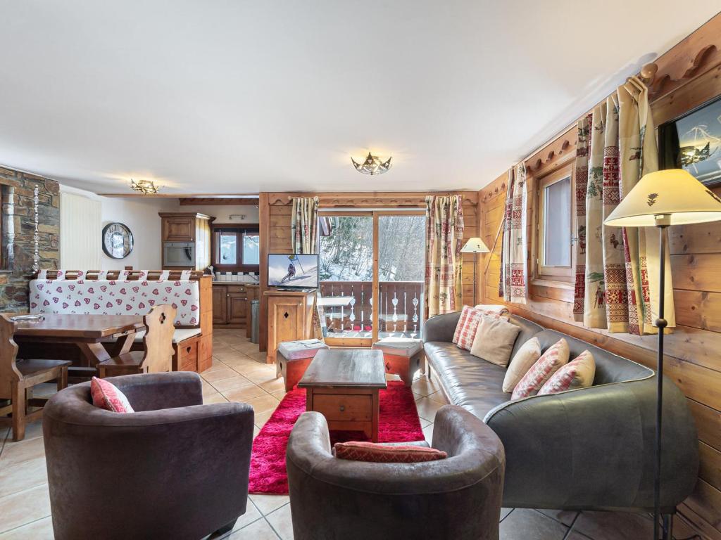 un salon avec un canapé, des chaises et une table dans l'établissement Duplex lumineux avec terrasse, piscine et spa à Méribel, accès direct aux pistes - FR-1-566-49, à Les Allues