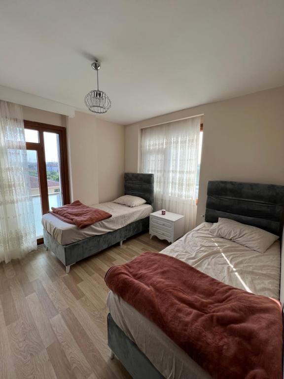 a bedroom with three beds and a window at İnci Sitesi in Tekirdag