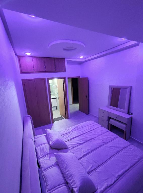 a purple room with a bed and a tv at Chalet villa QUE POUR LES FAMILLES in Imouzzer Kandar