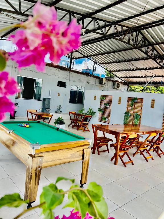 a pool table in a room with tables and chairs at Hostel Meio do Mundo in Macapá