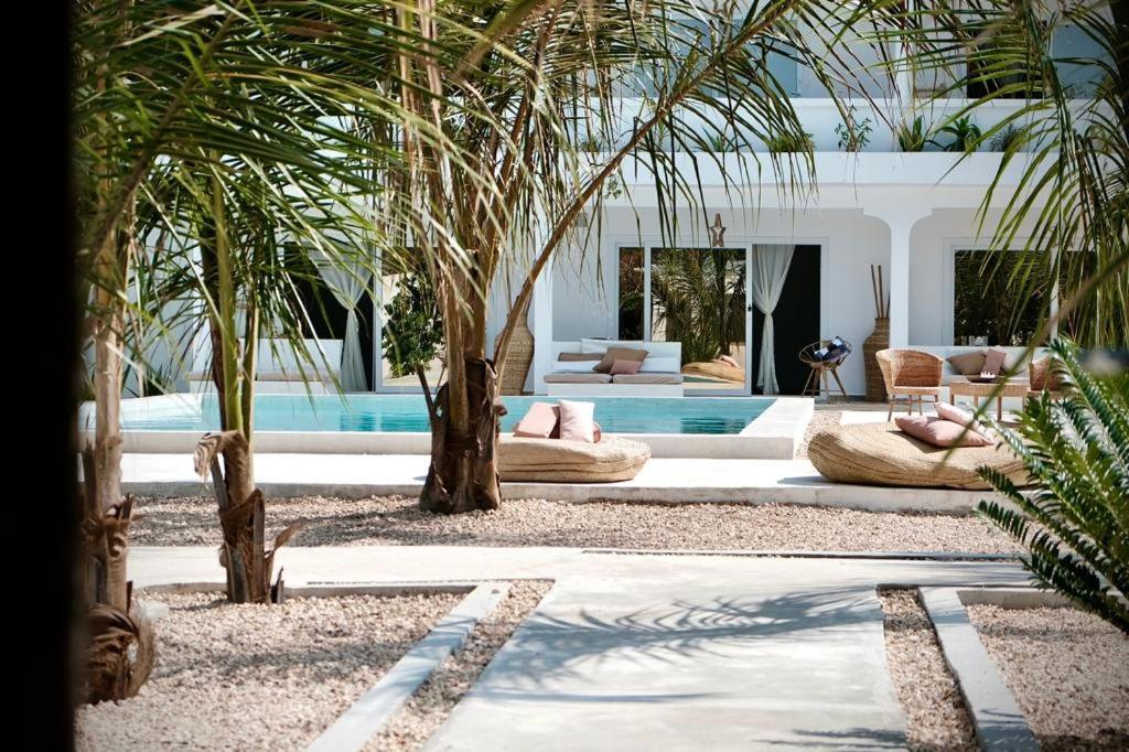 sala de estar con palmeras y piscina en Antares Villa, en Kiwengwa