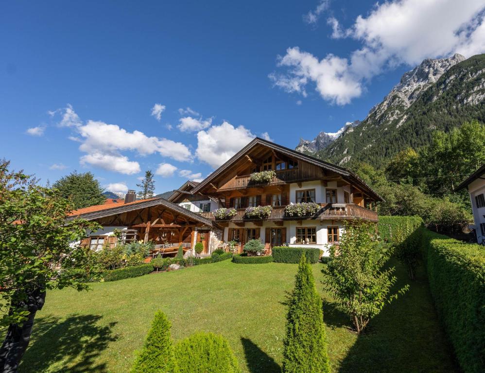 una casa en las montañas con un gran patio en Ferienhaus Alpenblick, en Mittenwald