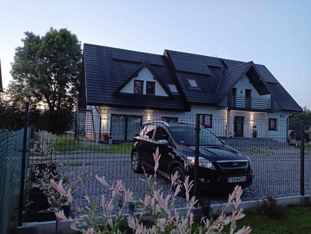 a black car parked in front of a house at Noclegi SKORUSINKA w pobliżu Chochołowskich Term in Witów
