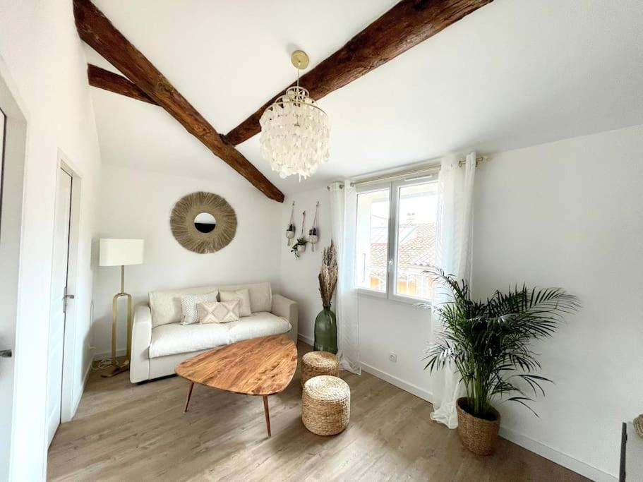 - un salon avec un canapé et une table dans l'établissement Ravissant appartement au cœur d’Aix, à Aix-en-Provence