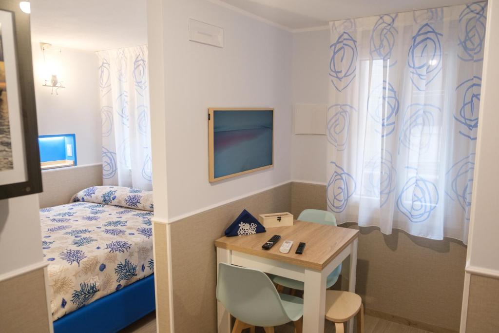 a room with a bed and a table and a desk at Appartamenti Vale Mare 2 in Chioggia