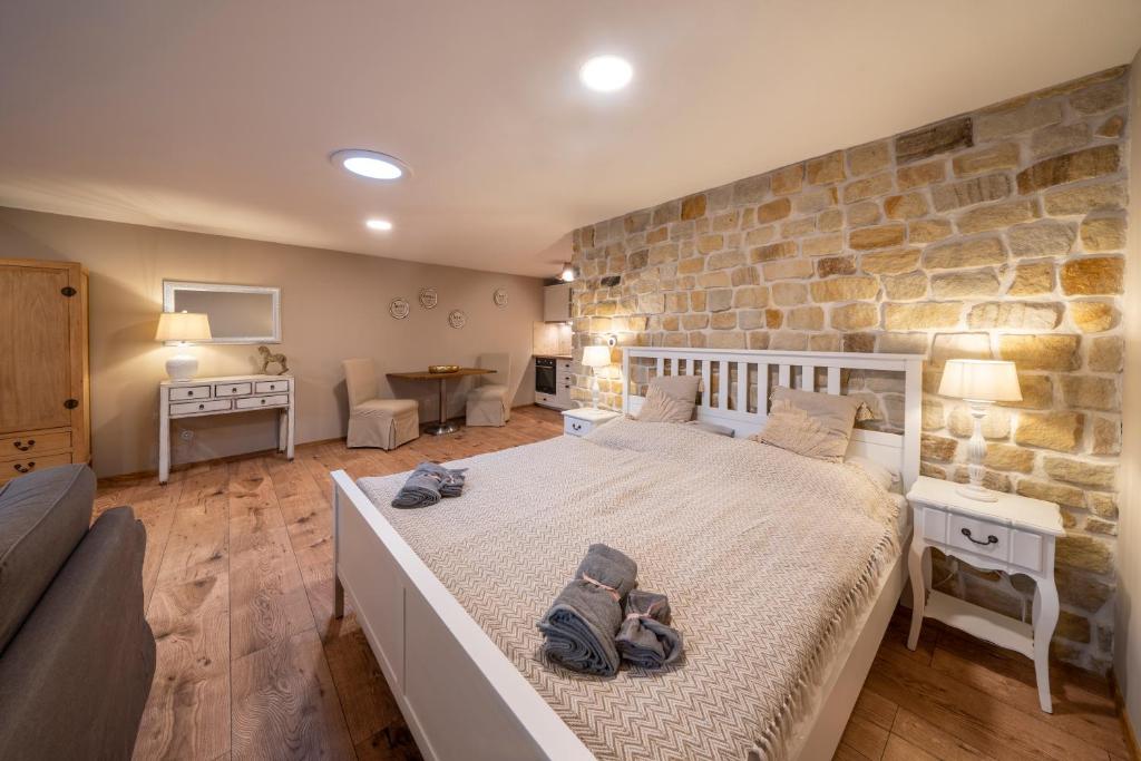 a bedroom with a large bed and a stone wall at Prague West - Studio Chyne Terrace in Chýně