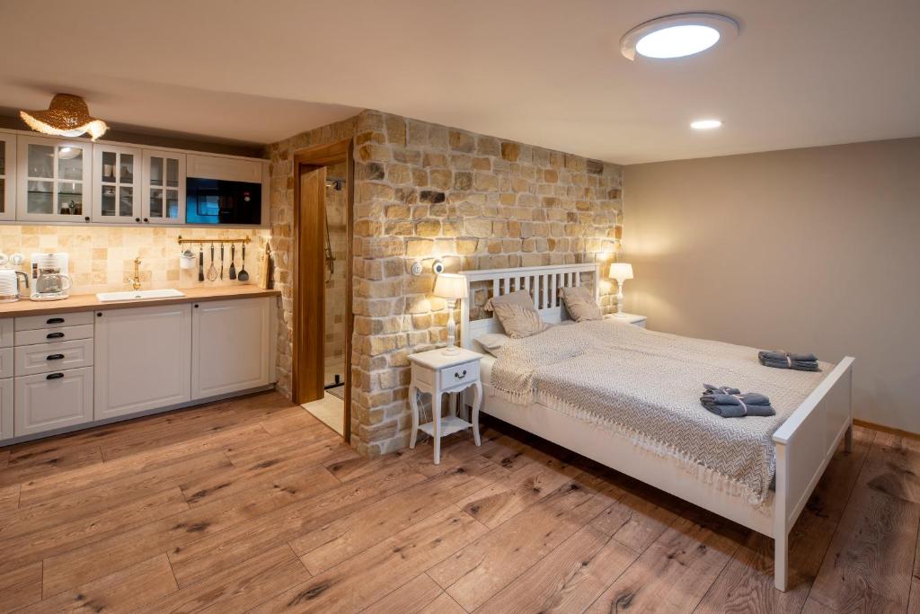 a bedroom with a bed and a stone wall at Prague West - Studio Chyne with Terrace in Chýně