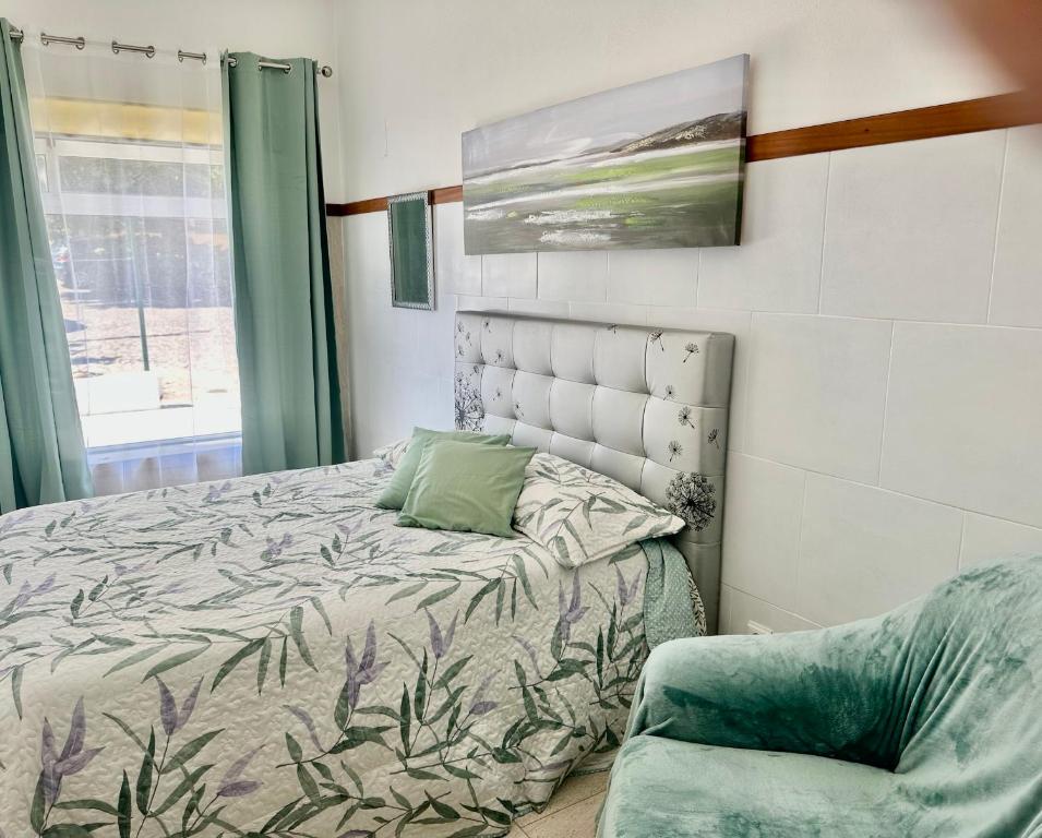a bedroom with a bed and a chair at Sweet Home - Praia das Rocas in Castanheira de Pêra