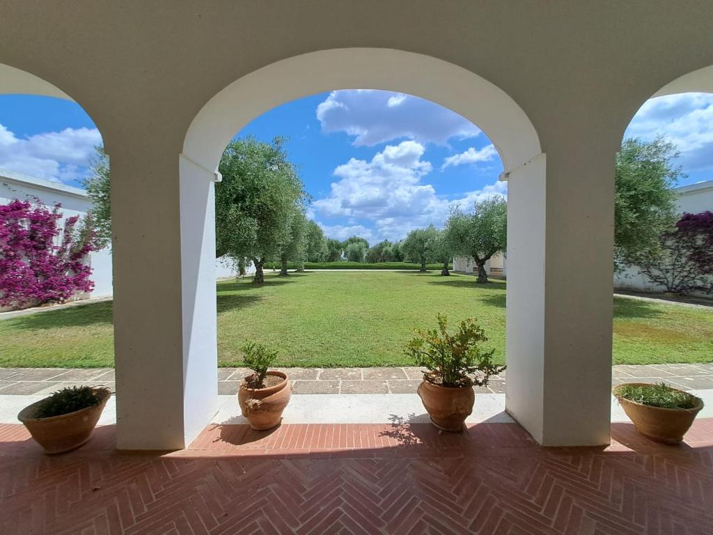 łuk z doniczkami i widok na dziedziniec w obiekcie Villa Francesca - Camere con giardino w mieście Castellaneta