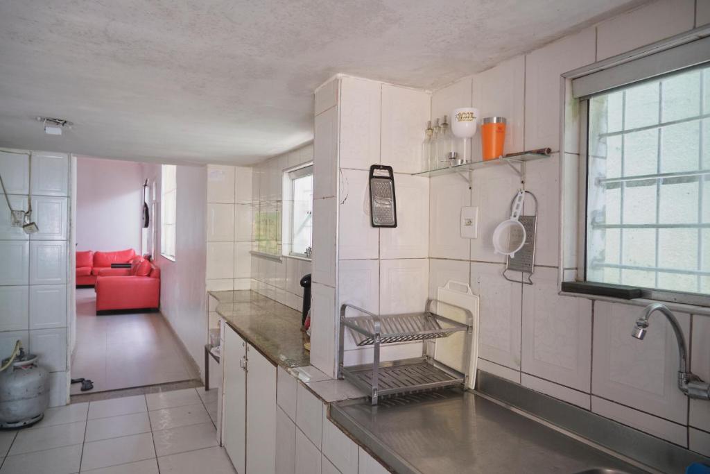 uma cozinha com um lavatório e um sofá vermelho em Belem Hostel em Belém