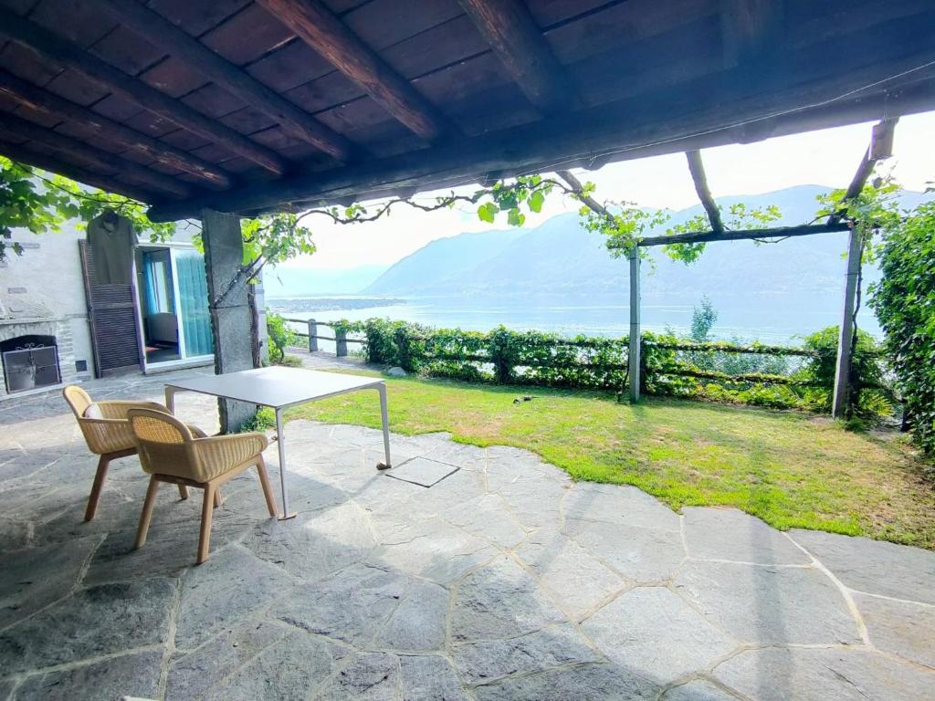 einen Tisch und Stühle auf einer Terrasse mit Meerblick in der Unterkunft "Pipistrello" in Ronco sopra Ascona