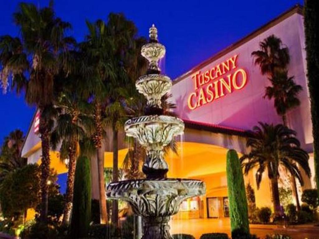 a statue of a man sitting on top of a palm tree at Tuscany Suites & Casino in Las Vegas