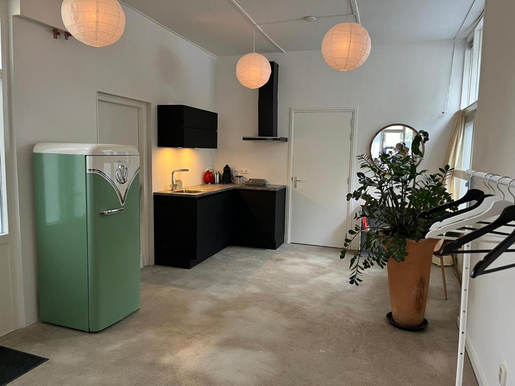 uma cozinha com um frigorífico verde num quarto em studio 4 em Workum