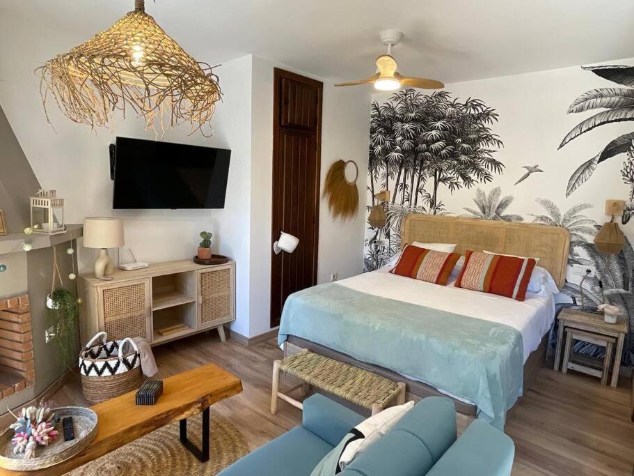 - une chambre avec un lit et un salon dans l'établissement Coqueto Estudio junto a Sierra Nevada, à Güéjar-Sierra