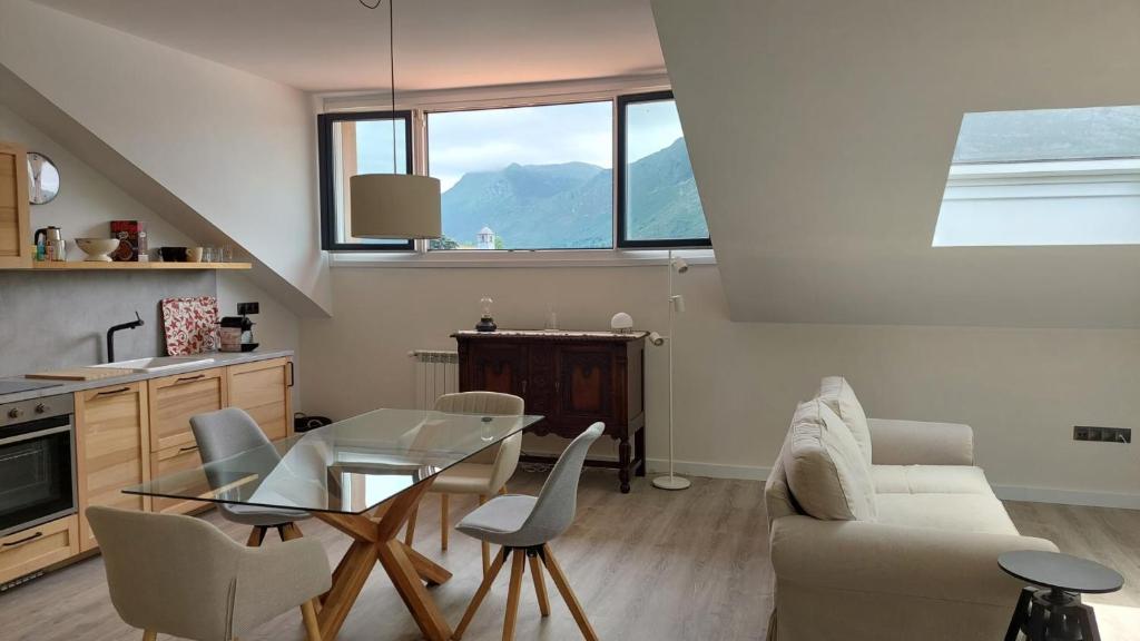 uma sala de estar com uma mesa de vidro e cadeiras em Apartamento en Posada de Llanes em Posada de Llanes
