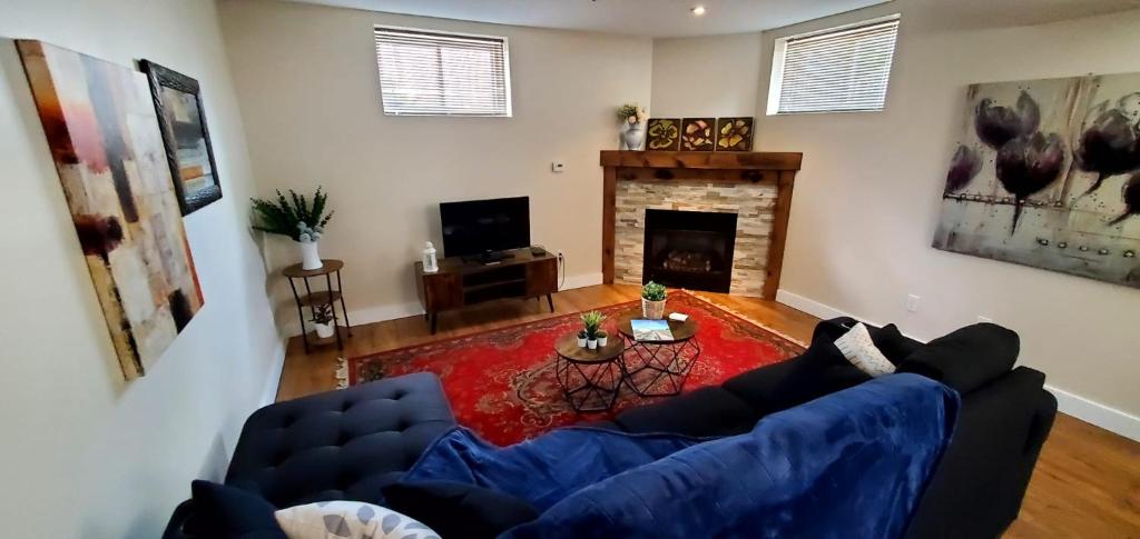 un soggiorno con un divano blu e un camino di Spacious Guest Suite a Hamilton