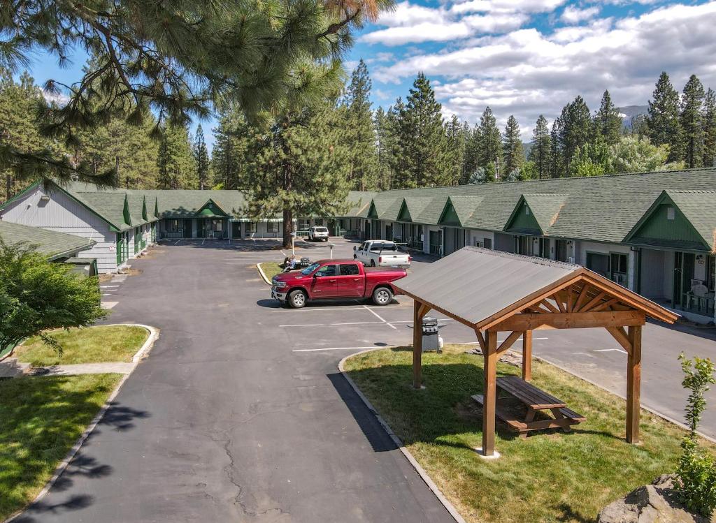 a parking lot with a red truck in front of a building at Green Gables Motel & Suites in Burney