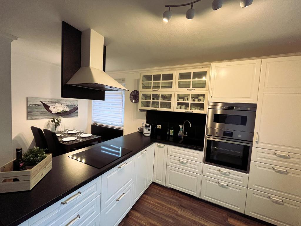 een keuken met witte kasten en een zwart aanrecht bij Apartment Igel im Herzen von Braunlage in Braunlage