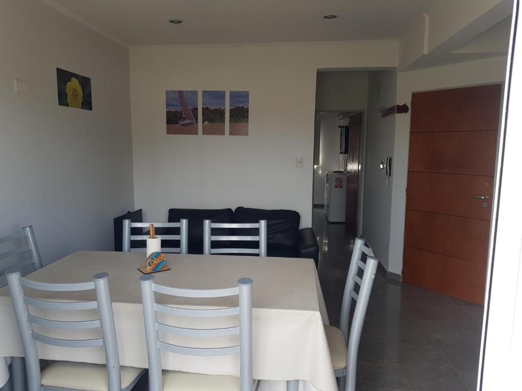 a dining room table with chairs and a couch at Colòn Termas y Playa - Departamento 2 a 4 personas in Colón