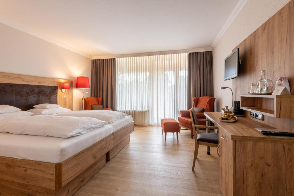 バート・ベヴェンセンにあるHotel Sonnenhügelのベッドとデスクが備わるホテルルームです。