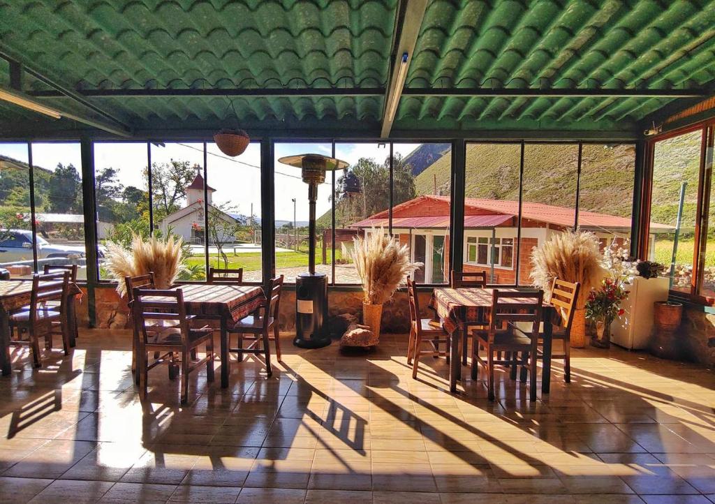 eine Terrasse mit Tischen und Stühlen und einem grünen Dach in der Unterkunft HOTEL MIL ESTRELLAS-TOROTORo in Potosí