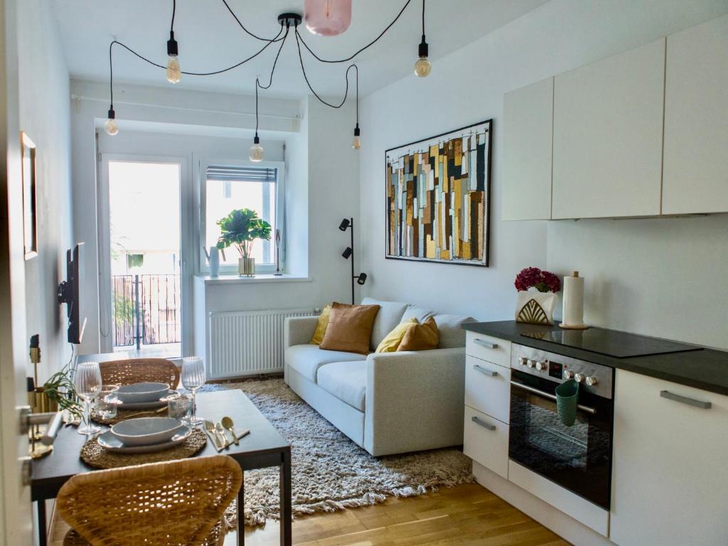 a kitchen and living room with a couch and a table at Cozy City Apartment in Graz