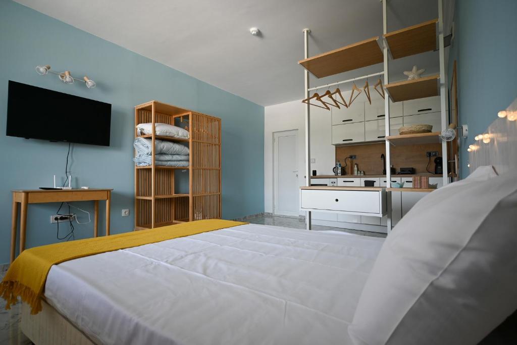 a bedroom with a large white bed and a television at Summer H. Studio Sunny Beach in Sunny Beach