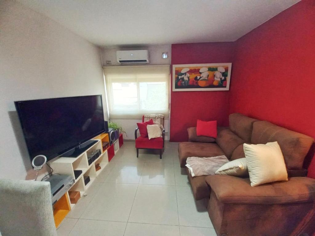 sala de estar con sofá y TV de pantalla plana en ROSARIO Oroño y Cordoba COCHERA en Rosario