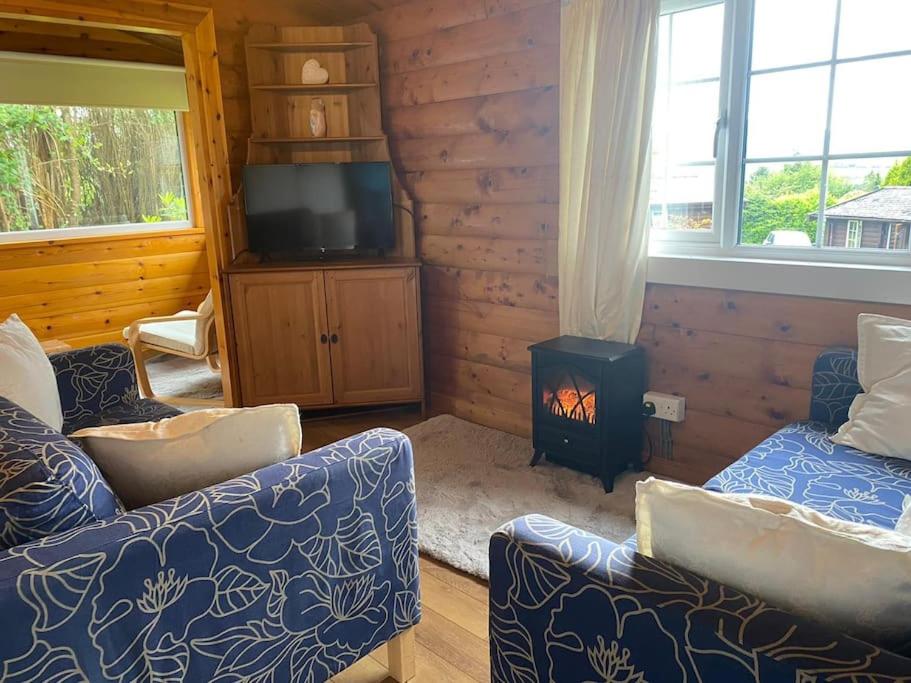 a living room with a couch and a stove at Cabin in Trawsfynydd