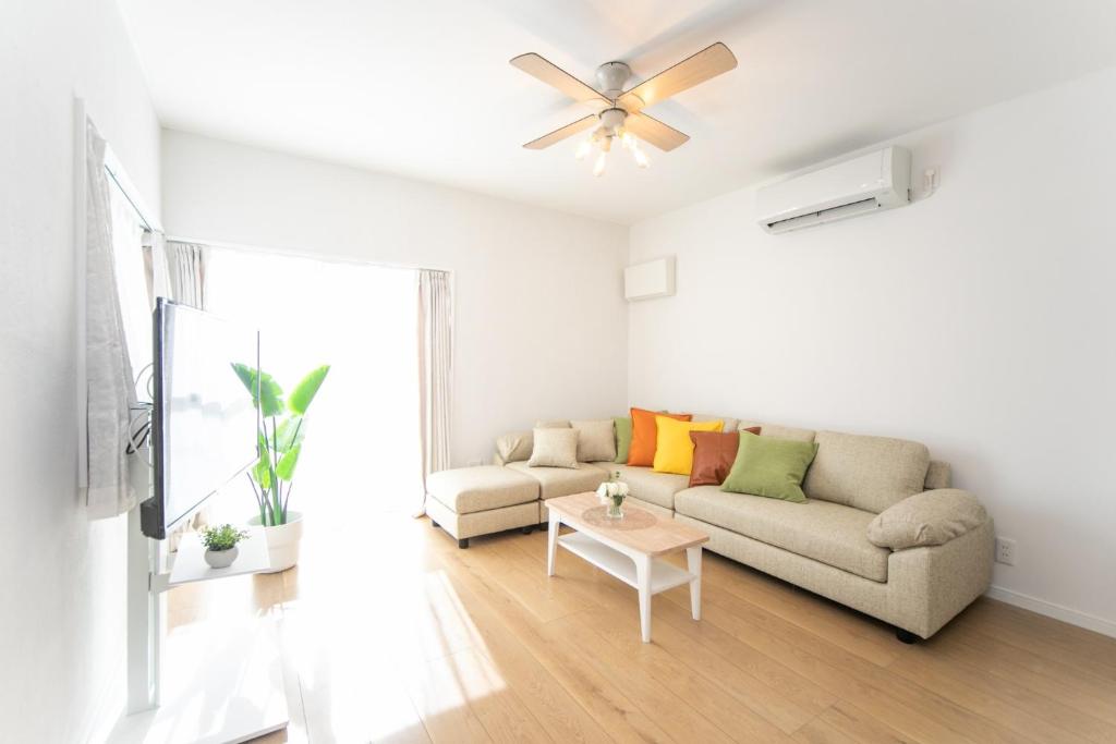 een woonkamer met een bank en een plafondventilator bij ナガシマリバーサイドリゾート - Vacation STAY 94113v in Kuwana