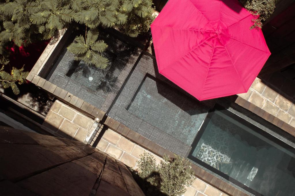 eine Aussicht auf einen rosa Regenschirm neben einem Pool in der Unterkunft Elena de Cobre, Leon, a Member of Design Hotels in León