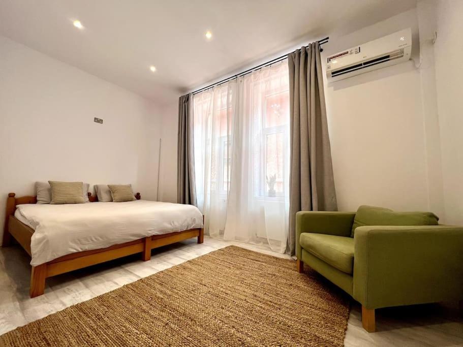- une chambre avec un lit, un canapé et une fenêtre dans l'établissement Apartament la casă în Centrul Orăștiei, à Orăştie