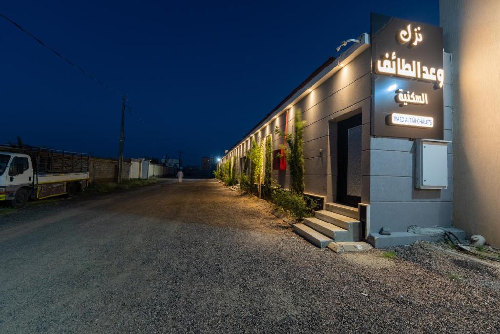 um sinal na lateral de um edifício à noite em Taif promise Chalets em Taif