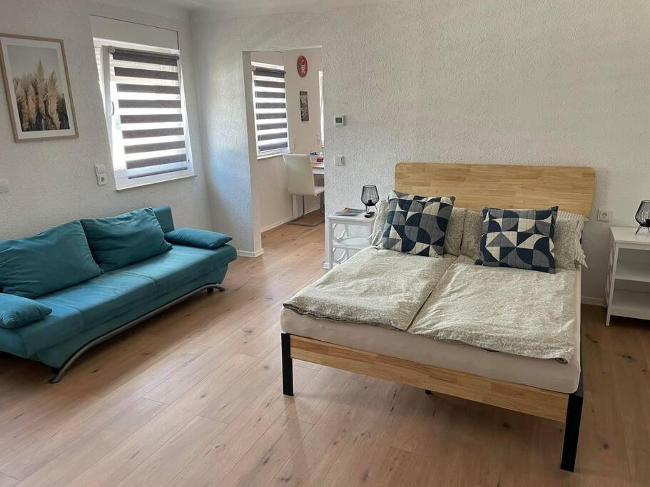 a living room with a bed and a blue couch at Apartment Mirabelle 4 in Püttlingen