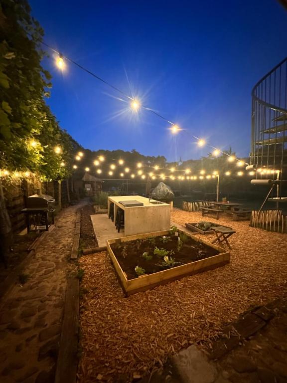 um pátio com um jardim à noite com luzes em Lodge 1854 em Densborn