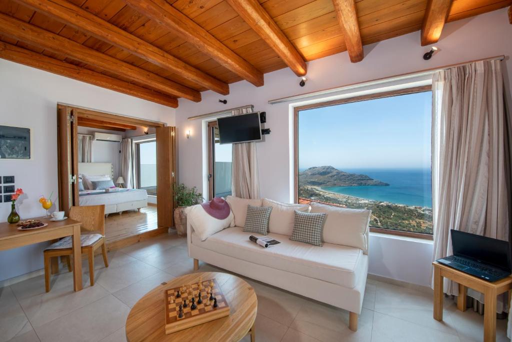 a living room with a view of the ocean at Stefanos Village Hotel in Plakias