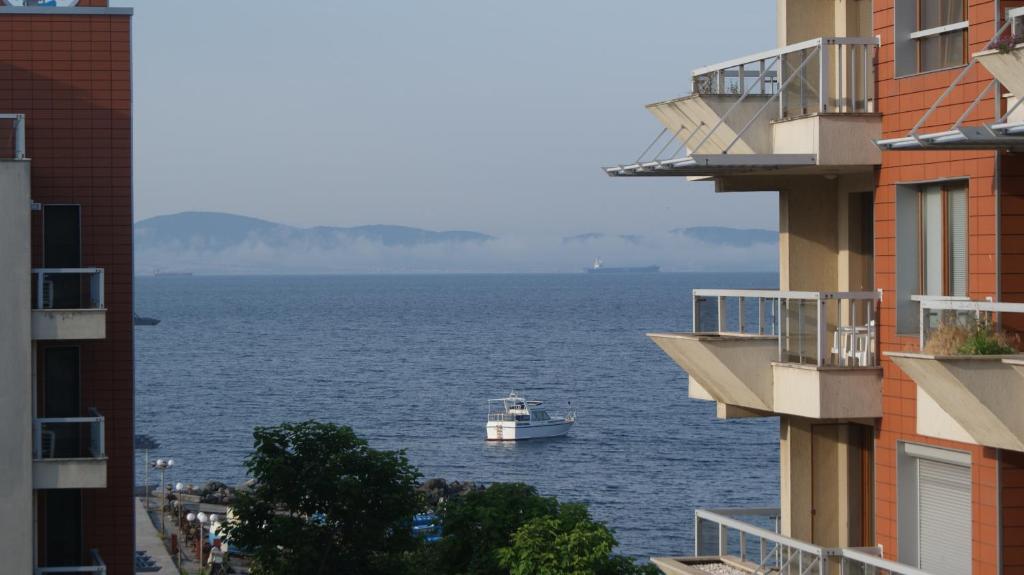 a boat in the water between two buildings at Cozy apartment with sea view in Pomorie