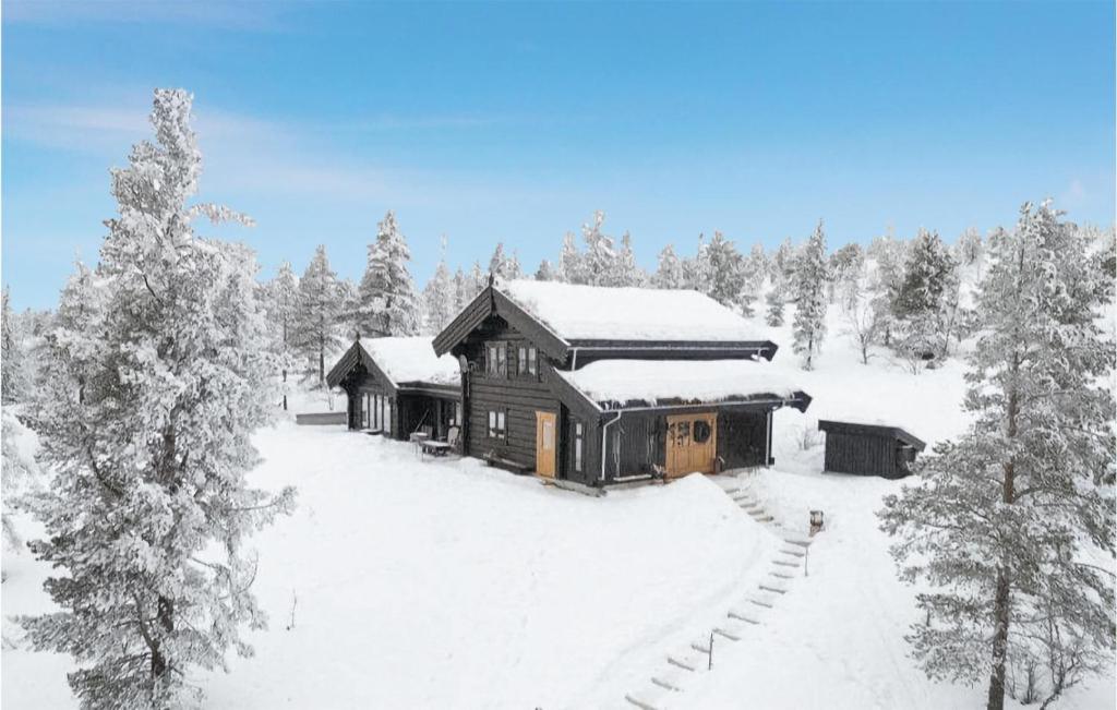 une cabane en rondins dans la neige avec des arbres enneigés dans l'établissement 5 Bedroom Gorgeous Home In Tynset, à Tynset