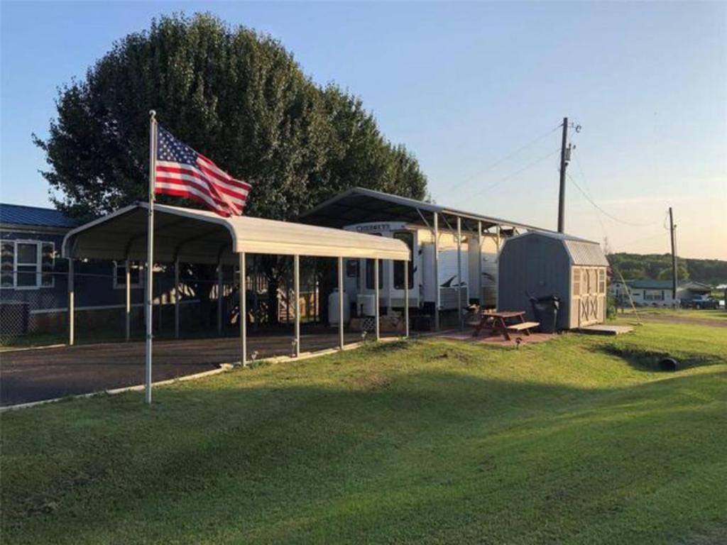 ein Zelt mit amerikanischer Flagge und einem Picknicktisch in der Unterkunft Bass Capital Rentals LLC in Quitman