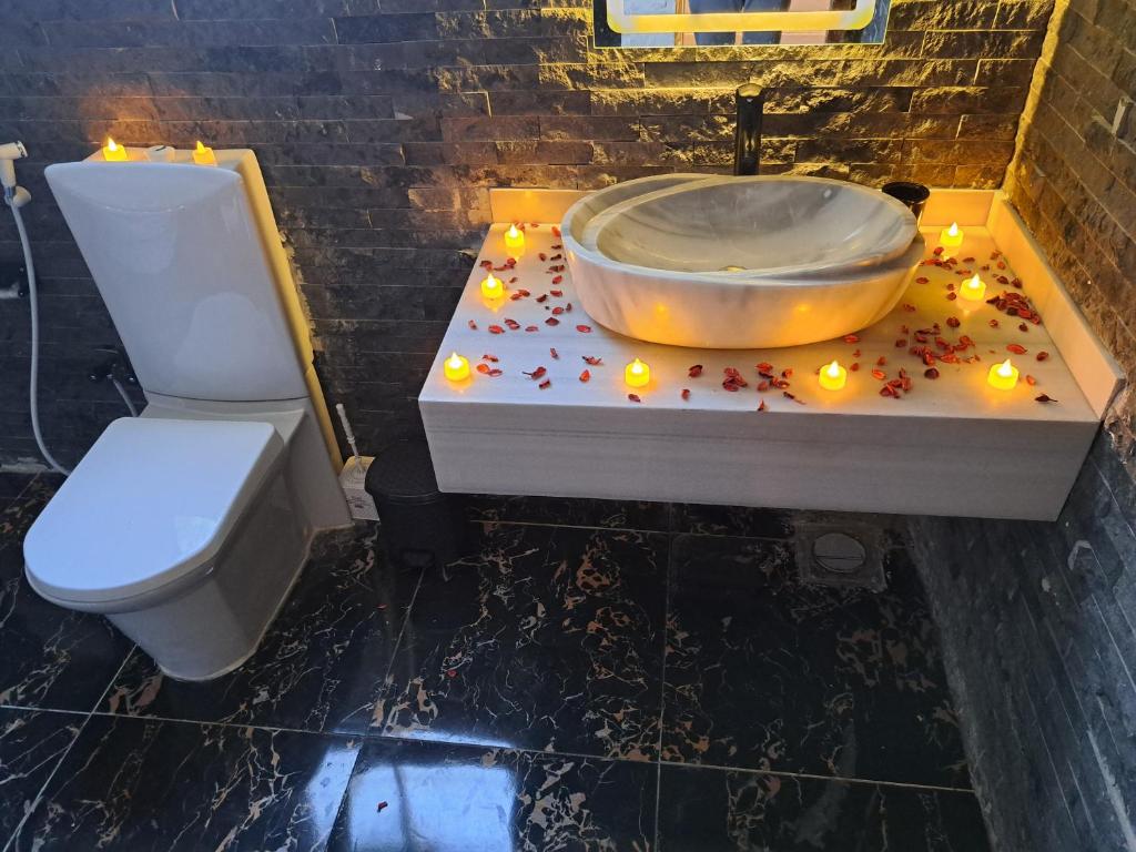 a bathroom with a sink and a toilet and candles at downtown Family Suites in Cairo