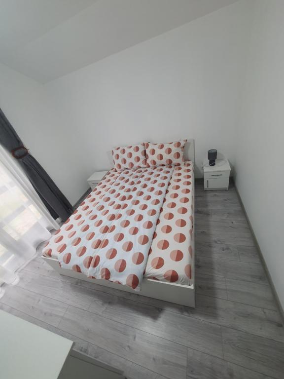 a white bed with red polka dot sheets in a room at Cabana Miraj in Groşii Ţibleşului