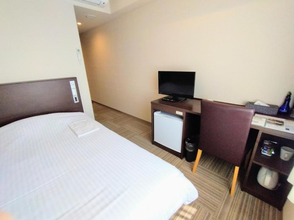 pokój hotelowy z łóżkiem i telewizorem w obiekcie New Matto Terminal Hotel - Vacation STAY 01864v w mieście Hakusan